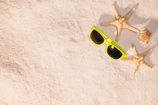 Солнечные очки и морские звезды на пляже