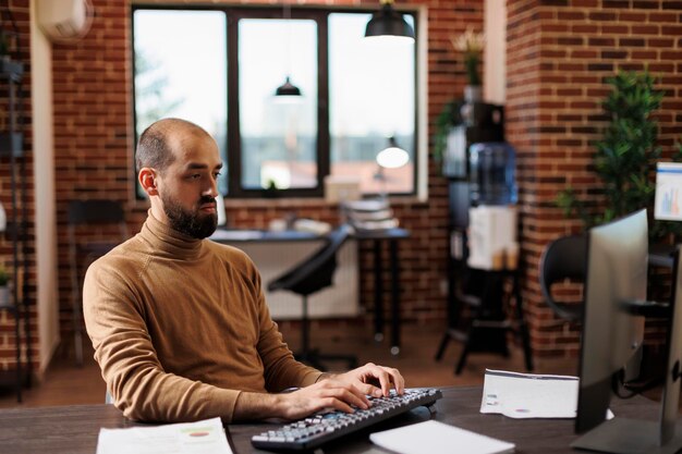 Startup project manager analyzing research results and accounting data. Research department team leader working on financial solutions while sitting at desk and using work computer.