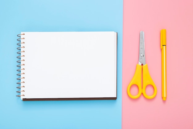 Stationery arrangement on bicolor background