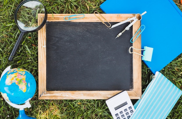 Stationery and chalk board set on green lawn 