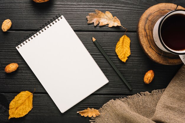 Stationery and leaves near tea and cloth