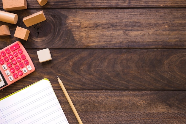 Stationery lying near calculator and geometric figures