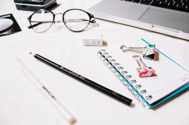 Stationery near glasses and laptop