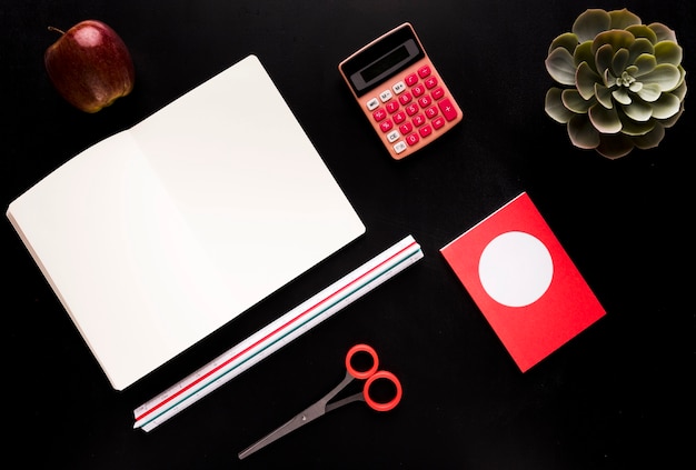 Stationery with fruit on black table