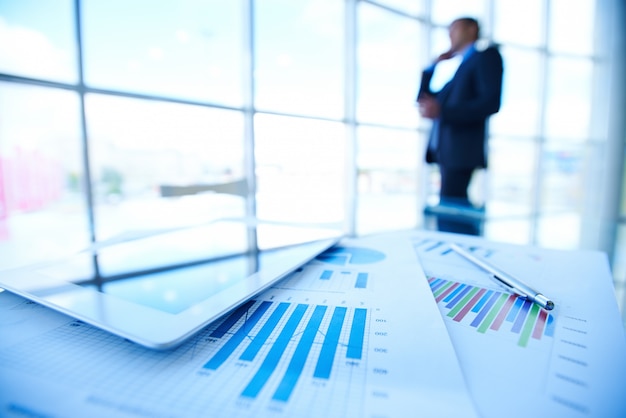 Statistic documents on a desk with businessman