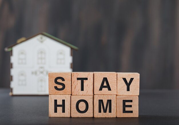 Stay home concept with wooden cubes, house model grey.