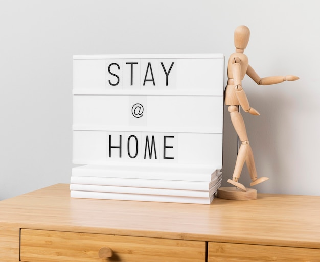 Stay at home inscription with wooden mannequin