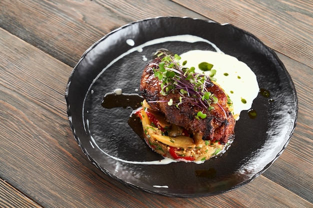 Steak served with grilled vegetables and sour cream