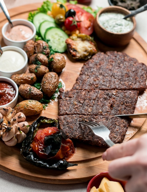 steak with fried potatoes and vegetables on wooden board 