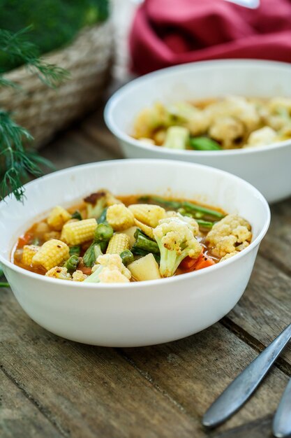 Steamed vegetables in a bowl on wooden table