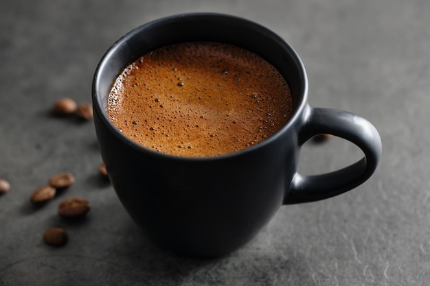 Steaming espresso cup on grey background. Closeup