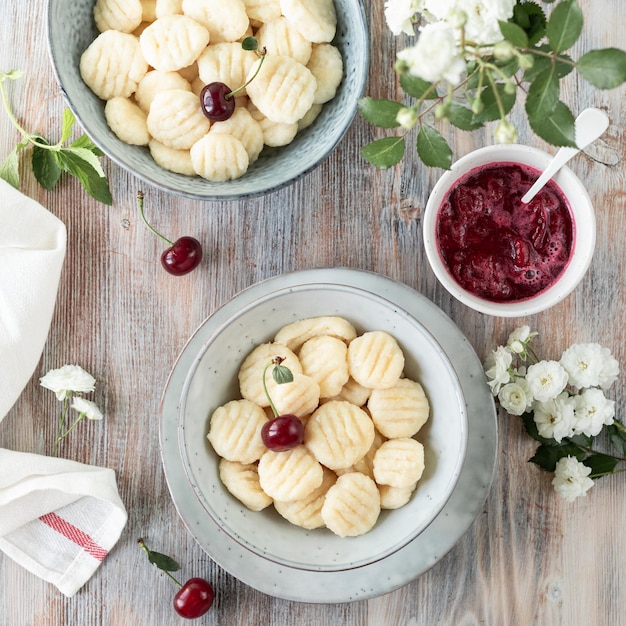 Step 3 The process of cooking dumplings Homemade cottage cheese dumplings with cherry sauce on a wooden background A traditional Ukrainian dish Square