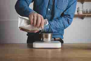 Free photo step by step aero press coffee preparation
barista in blue jeans shirt pours roasted beans from bag to steel cup on white weights
professional coffee brewing cafe shop