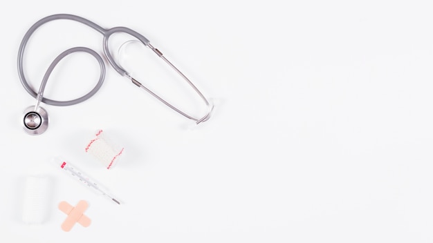 Stethoscope and bandages with thermometer isolated on white background