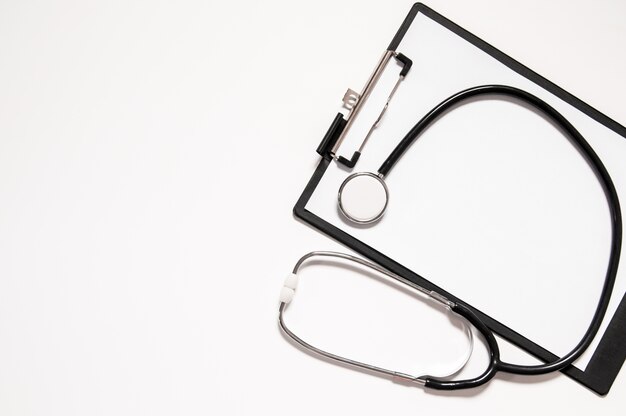 Stethoscope and blank clipboard isolated on white