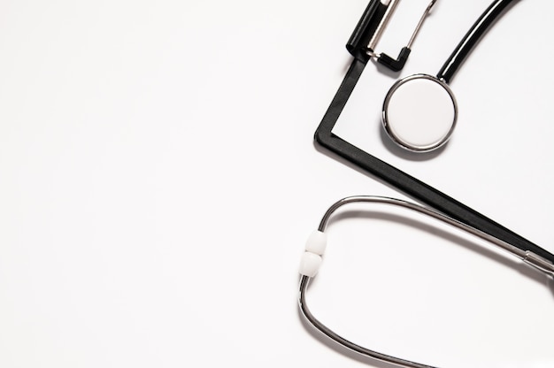 Stethoscope and blank clipboard isolated on white