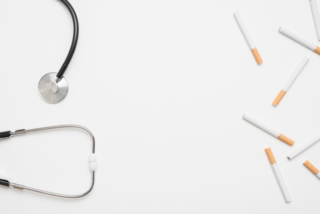 Stethoscope and cigarettes above white backdrop