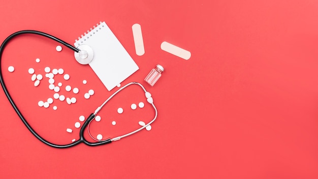Stethoscope and medications near notebook