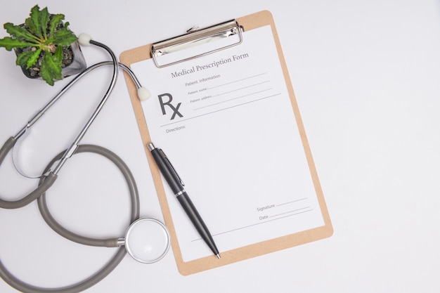 Stethoscope, a pen and a blank prescription pad.  Medicine or pharmacy concept. Empty medical form ready to be used. Modern medical Information technology.