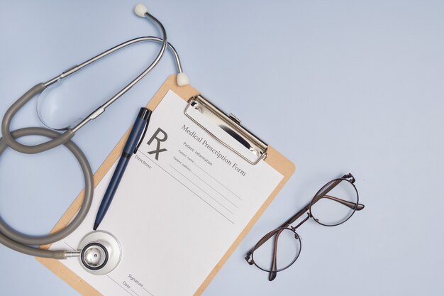 Stethoscope, a pen and a blank prescription pad.  Medicine or pharmacy concept. Empty medical form ready to be used. Modern medical Information technology.