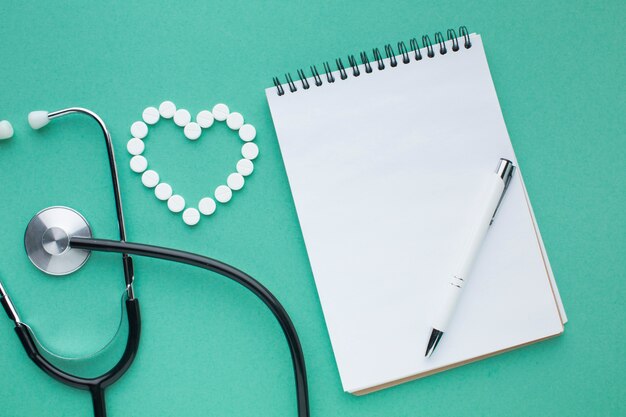 Stethoscope and pills with notepad