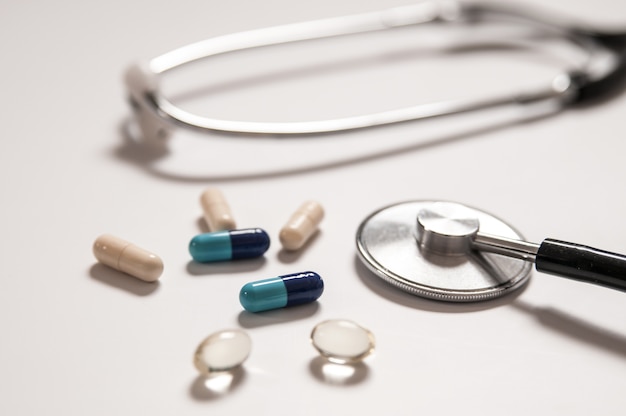 Stethoscope on white background with mix pills isolated