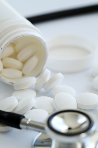 Stethoscope and white pills closeup. Healthcare