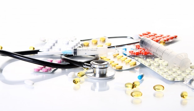 Бесплатное фото Стетоскоп с различными фармацевтическими препаратами