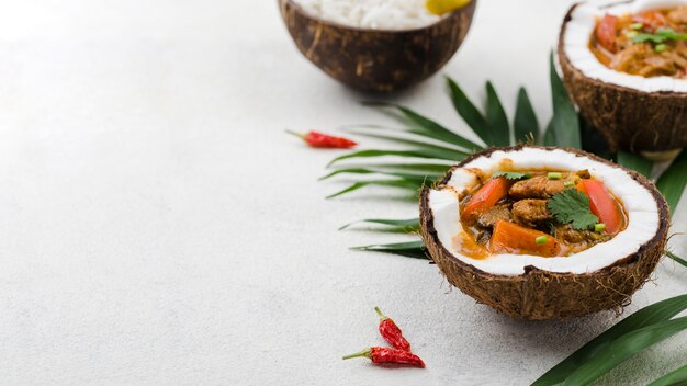 Stew and rice in coconut plates with jalapenos