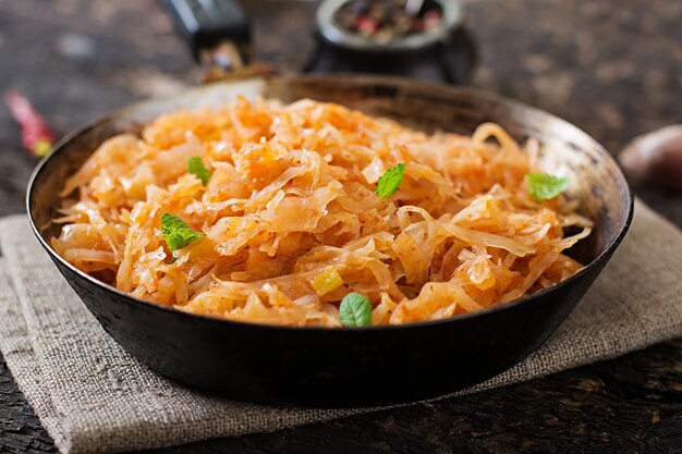 Stewed cabbage on the old wooden table in rustic style