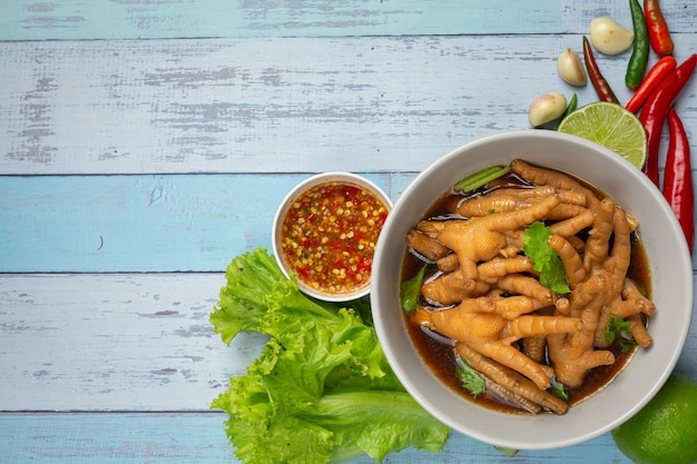 鶏の足の煮込みスープにスパイシーな魚醤を添えて