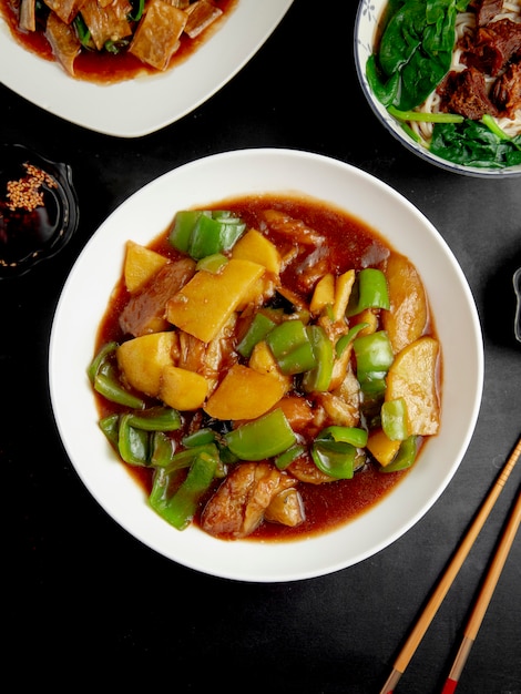 Free photo stewed chicken with pumpkin and peppers on black table