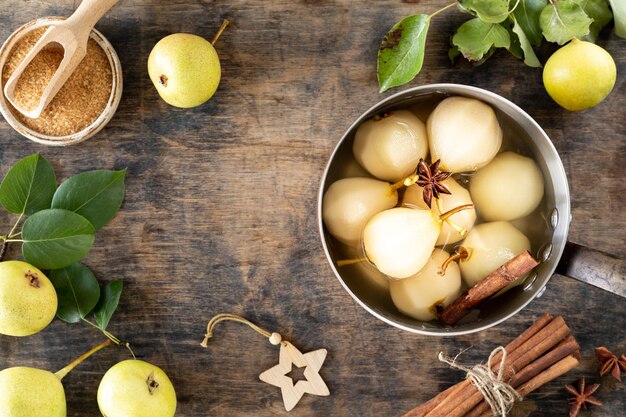 Free photo stewed pears pot of sweet pears stewed in syrup or white wine on a green wooden table the cooking process