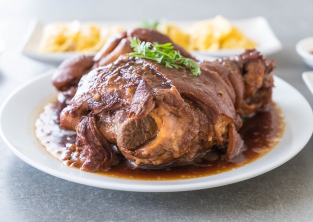 Free photo stewed pork leg in gravy soup