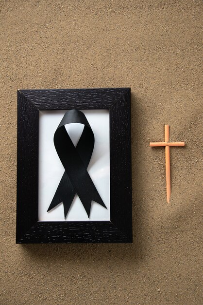 Stick cross with picture frame on the sand