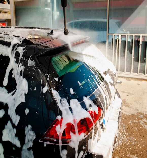 Stick spraying water on a car