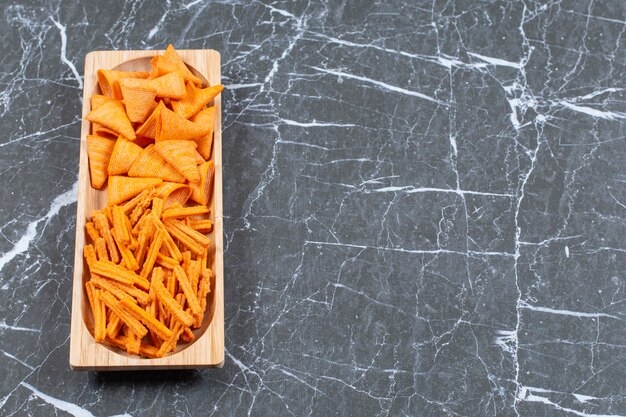 Free photo stick and triangle chips on wooden plate.