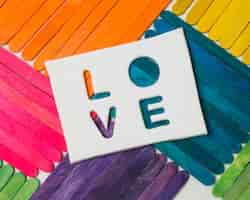 Free photo sticks in bright lgbt colors and love word on tablet