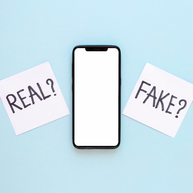 Free photo sticy notes with fake news beside phone