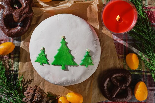 Still life of Christmas food with fruity English cake decorated with fir trees covered with marzipan Traditional Christmas cake or pudding on the background of Christmas decorations top view