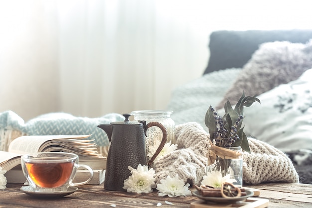 Бесплатное фото Натюрморт с деталями домашнего интерьера на деревянном столе с чашкой чая
