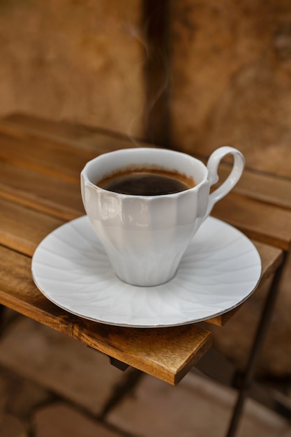 Натюрморт расслабляющей кофейной чашки на террасе