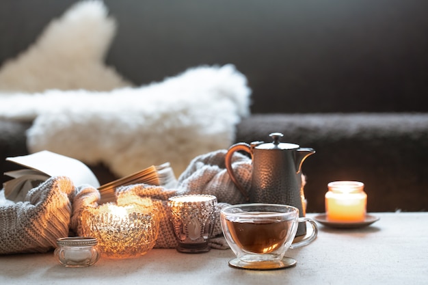 Still life with a cup of tea, a teapot and beautiful vintage candlesticks with candles.