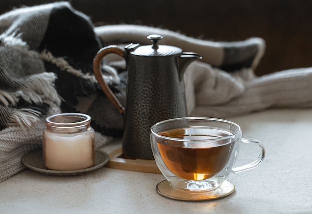 Foto gratuita natura morta con una tazza di tè, una teiera, un libro e dettagli di arredo