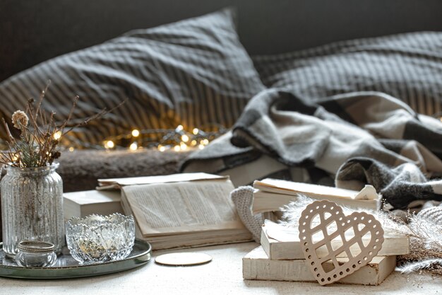 Still life with a decorative heart, books and cozy things on a blurred background with bokeh. The concept of Valentine's day.