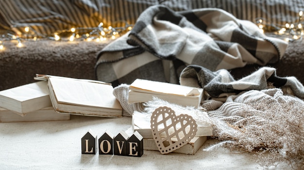 Still life with the decorative word love, books and cozy things.