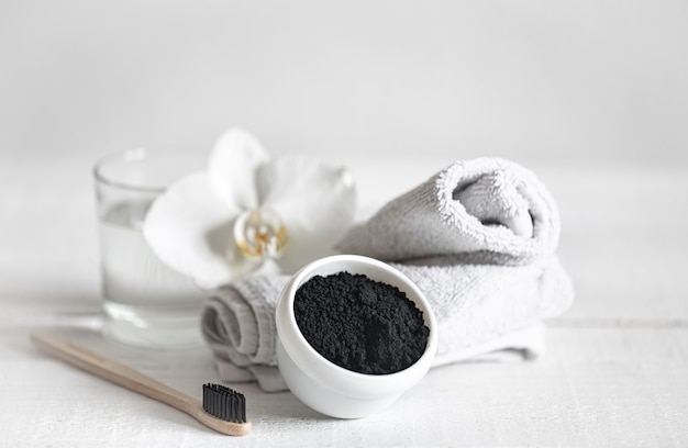 Free photo still life with an organic wooden toothbrush with a glass of water and natural teeth whitening powder. oral hygiene and dental care.