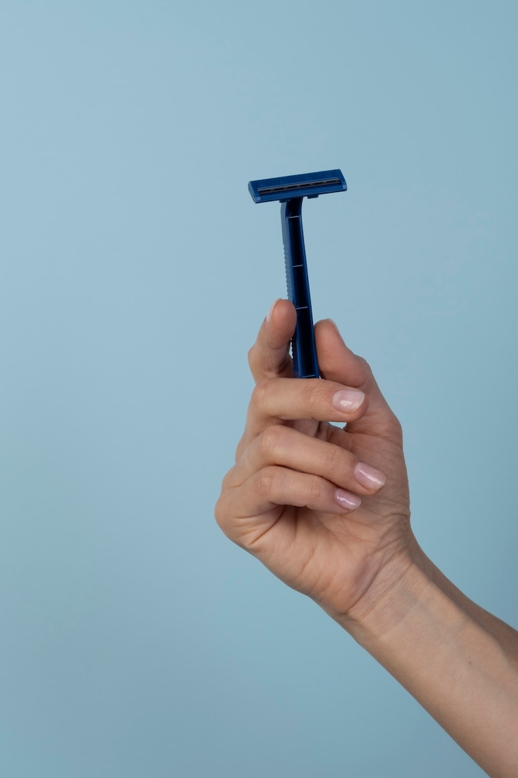 Free Photo still life with razor blade held in hand