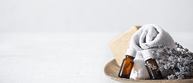 Still life with towels, soap and aromatic oils in jars. Aromatherapy and health care concept.