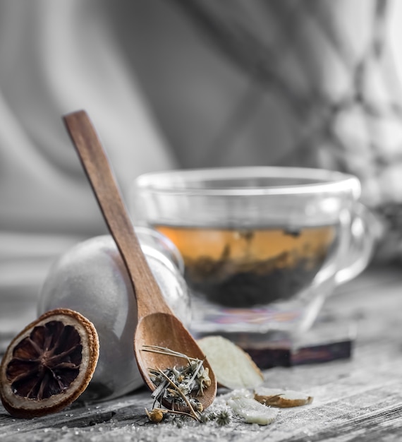 Натюрморт с прозрачной и ароматной чашкой чая с имбирем на деревянном фоне
